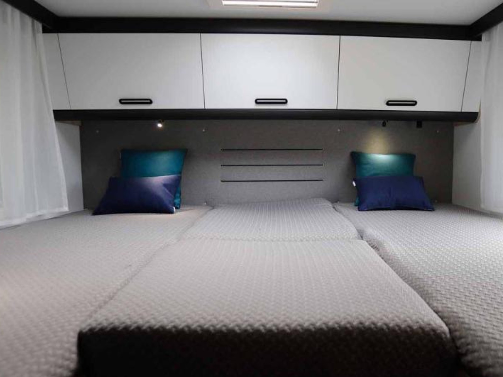 Lengtebed achterin de Sun Living S72DL camper, met twee aparte bedden, comfortabele matrassen en opbergruimte eronder